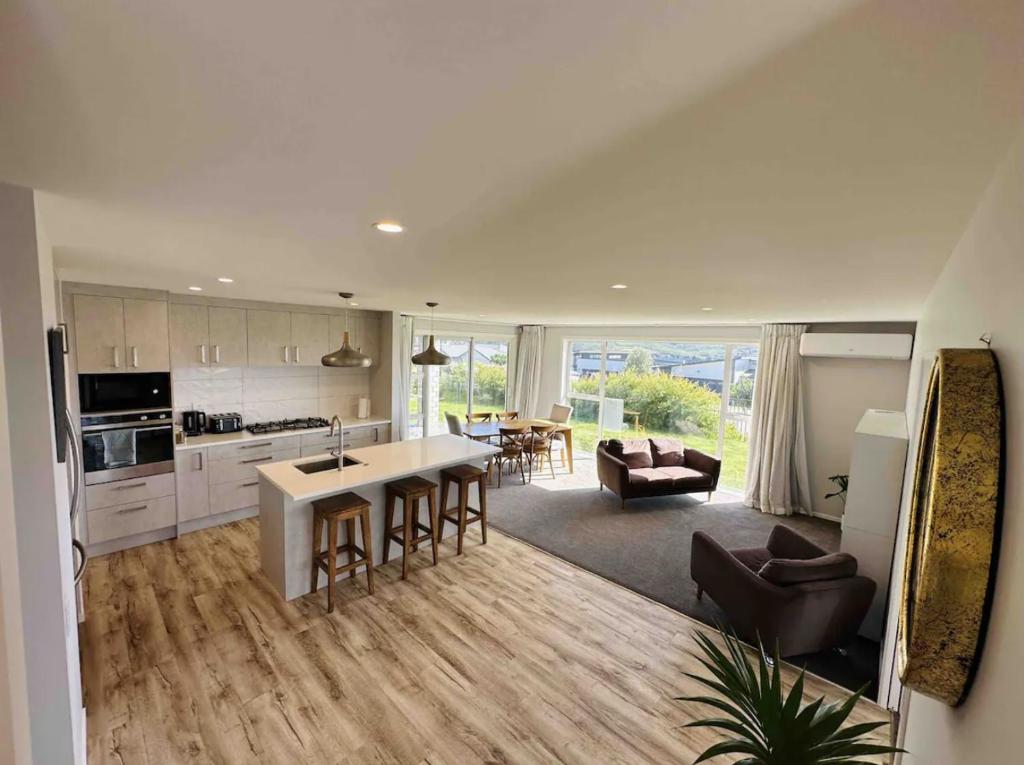 a kitchen and living room with a table and chairs at Lovely Family Home in Aotea with Grear Views - No Parties or Smoking in Porirua