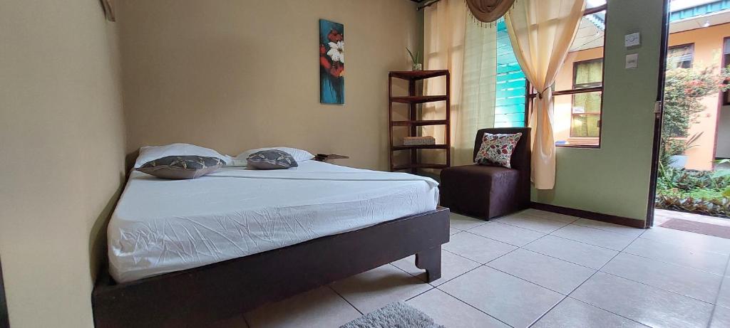利蒙的住宿－Hospedaje Doña koko，卧室配有床、椅子和窗户。