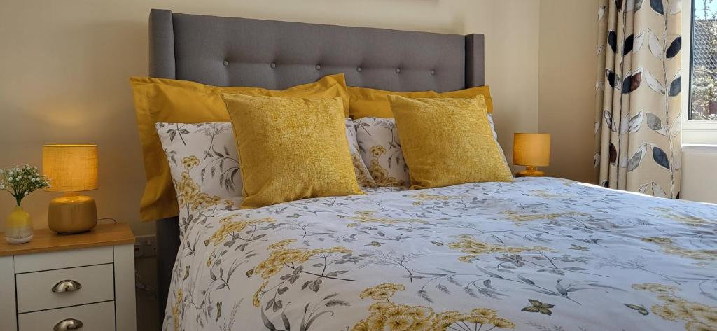 a bedroom with a bed with yellow pillows at The West Wick House in Weston-super-Mare