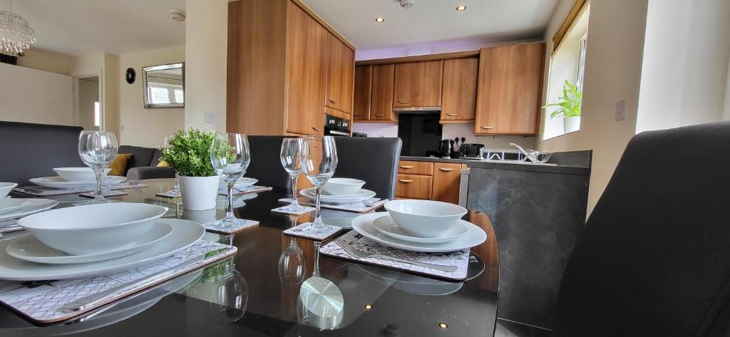 a kitchen with a table with plates and wine glasses at The West Wick House in Weston-super-Mare