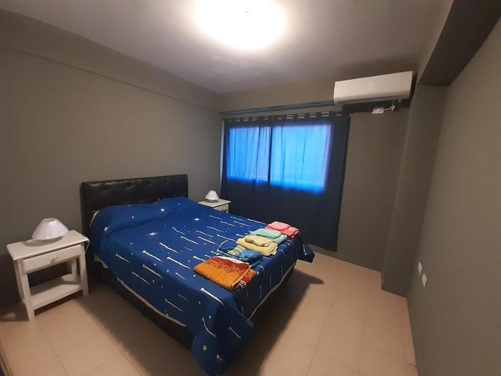 a bedroom with a blue bed and a window at Departamento Mate de Luna 2900 in San Miguel de Tucumán