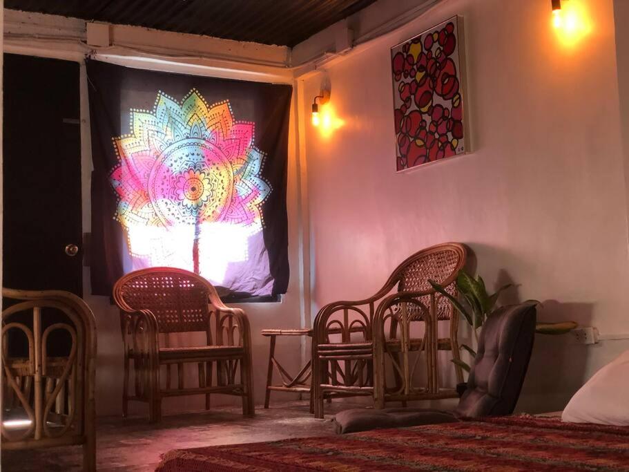 a room with two chairs and a screen with a painting at Casa Ausa - Bacnotan La Union in Bacnotan