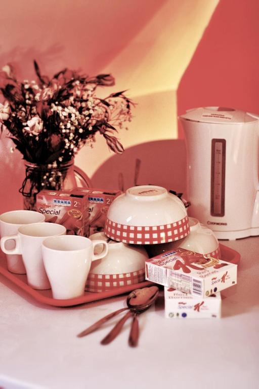 a table with cups and cups and a coffee maker at Beaconsfield Hotel in London