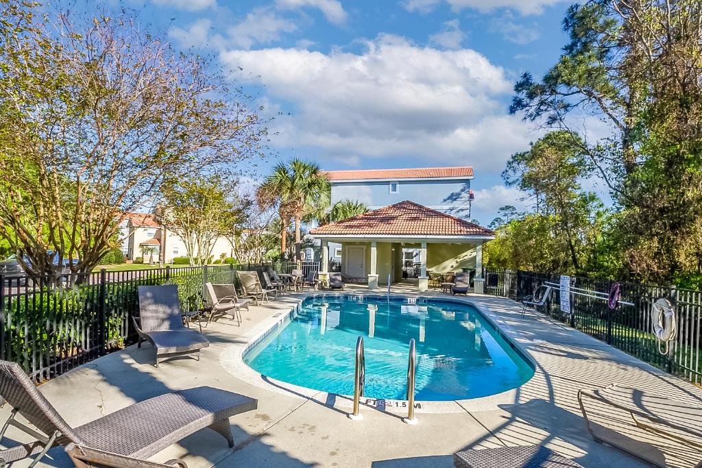 a swimming pool with chairs and a fence at Arborgate Gate Away At 7971 Double Gate Dr By Pkrm in Pensacola