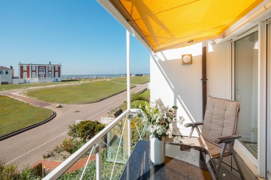 a balcony with a chair and a view of the ocean at Meerliebe in Norderney