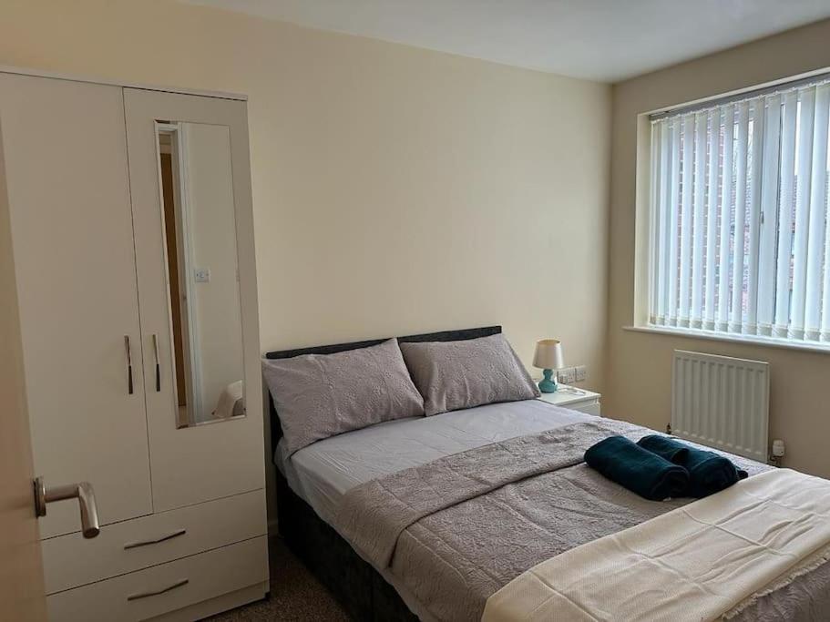 Rooms 7 minutes from Etihad في مانشستر: غرفة نوم بسرير ونافذة كبيرة