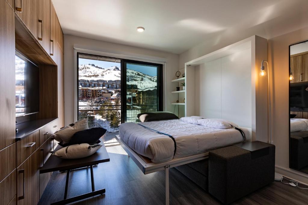 a bedroom with a bed and a large window at YotelPAD Park City Unit #432 in Park City
