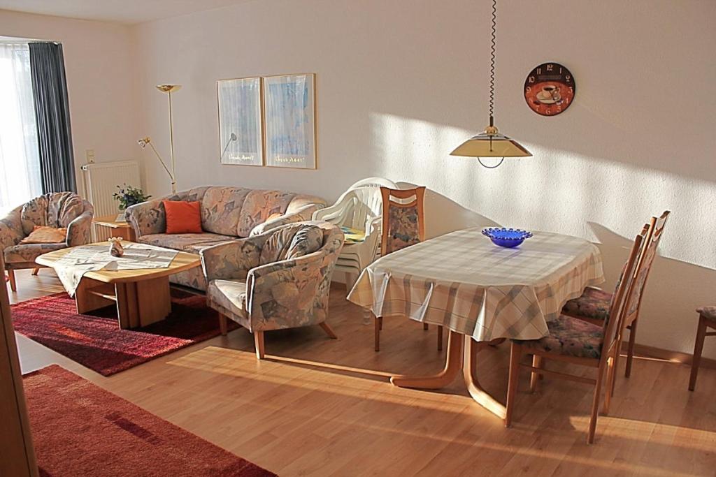 ein Wohnzimmer mit einem Sofa, einem Tisch und Stühlen in der Unterkunft Steife Briese in Dorum Neufeld
