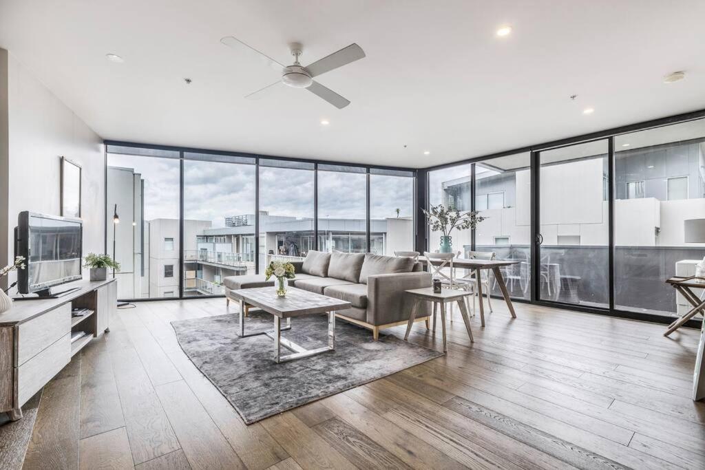 ein Wohnzimmer mit einem Sofa und einem Tisch in der Unterkunft Amazing Luxury Apartment & so close to the CBD - 01756 in Melbourne