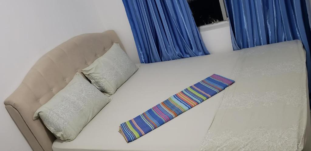 a couch with two pillows and a tie on it at Quarto em Apartamento Centro in Criciúma