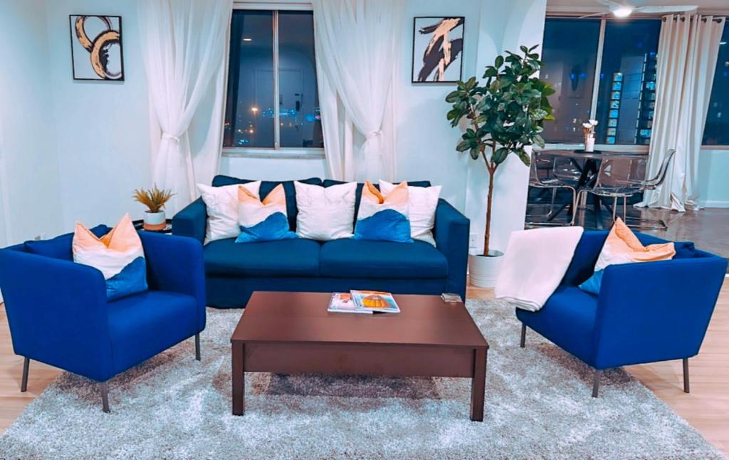 a living room with two blue couches and a coffee table at Highrise luxury two bedroom condo in Downtown Atlanta within minutes!! in Atlanta