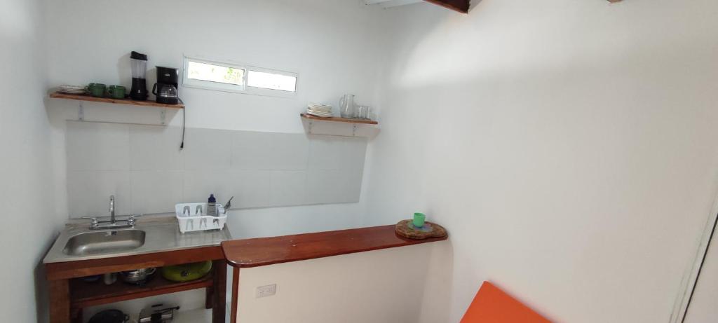 a kitchen with a sink and a white wall at Guest House Villa Hortensia in Santa Marta