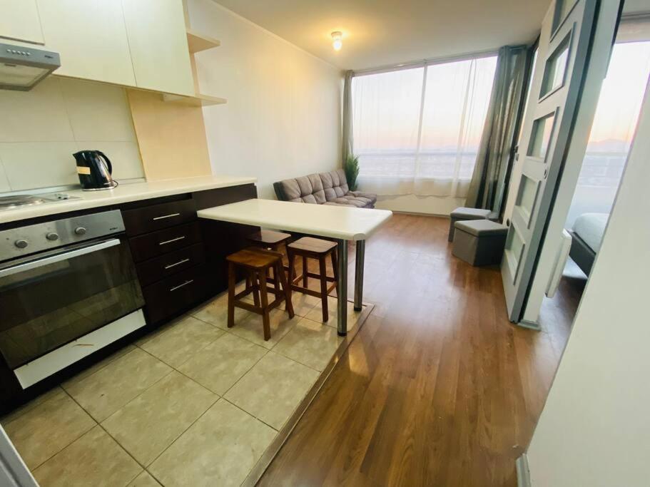 a kitchen with a table and chairs in a room at Céntrico Apartamento Frente al Metro in Santiago