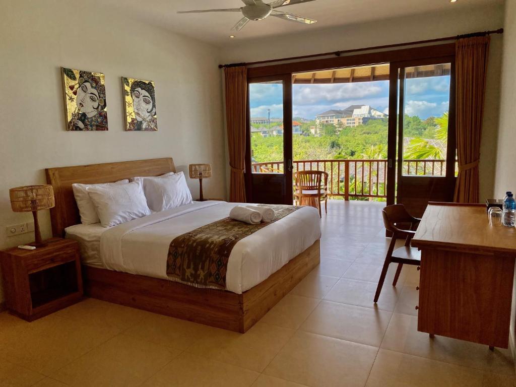 ein Schlafzimmer mit einem großen Bett und einem Balkon in der Unterkunft Bombora Balangan Resort in Ungasan