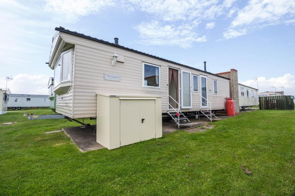 una casa móvil con garaje en un patio en Lovely 6 Berth Caravan At Naze Marine Holiday Park In Essex Ref 17003c, en Walton-on-the-Naze