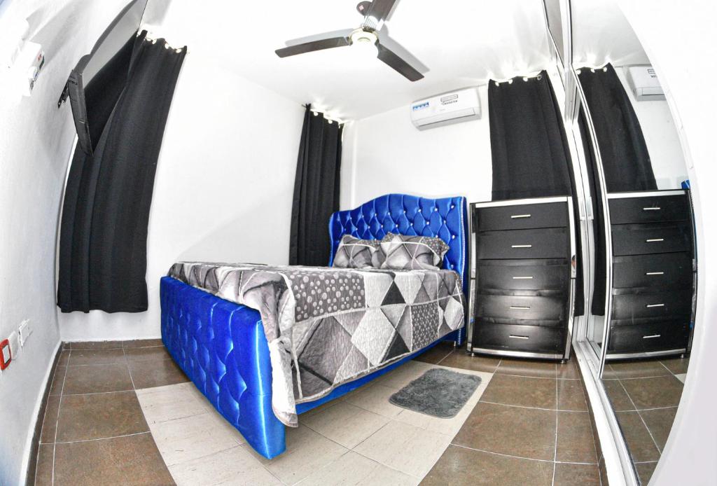 a bedroom with a blue bed and black cabinets at las carreras centro D la ciudad in Santiago de los Caballeros