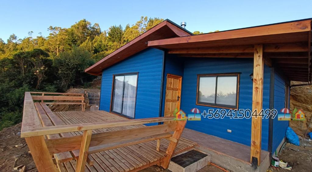 a blue tiny house with a wooden deck at Cabaña Playa Rosada in Valdivia