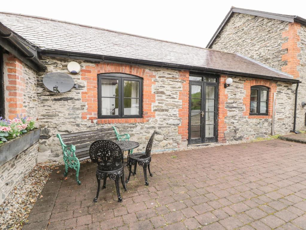 un patio con tavolo e sedie di fronte a un edificio di The Dairy a Corwen