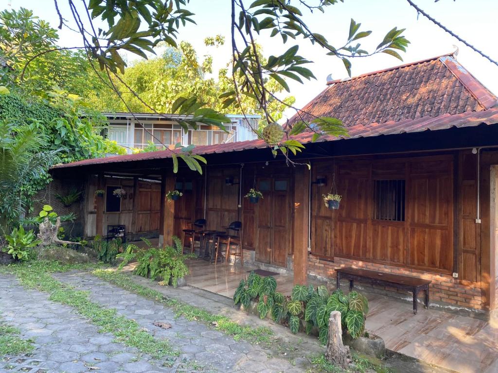 una casa de madera con un banco delante en StayBareng di Kasongan en Jarakan