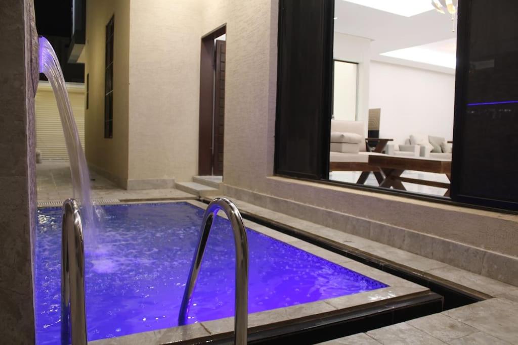 a swimming pool with purple water in a building at فيلا عصرية بمدخل خاص و مسبح in Riyadh