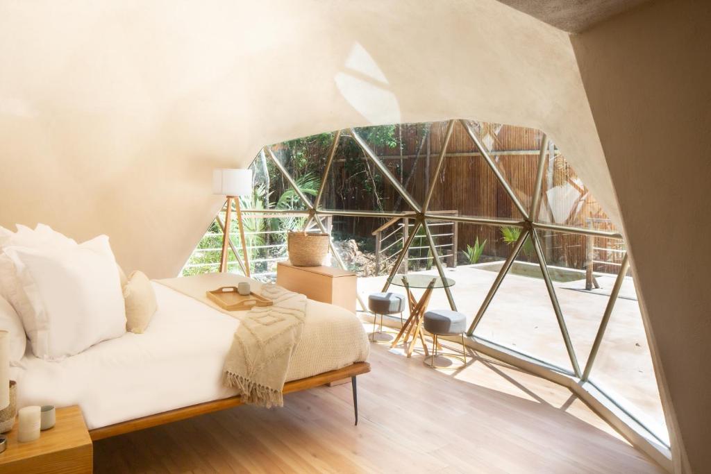 1 dormitorio con cama y ventana grande en Alma Maya Resort en Puerto Morelos