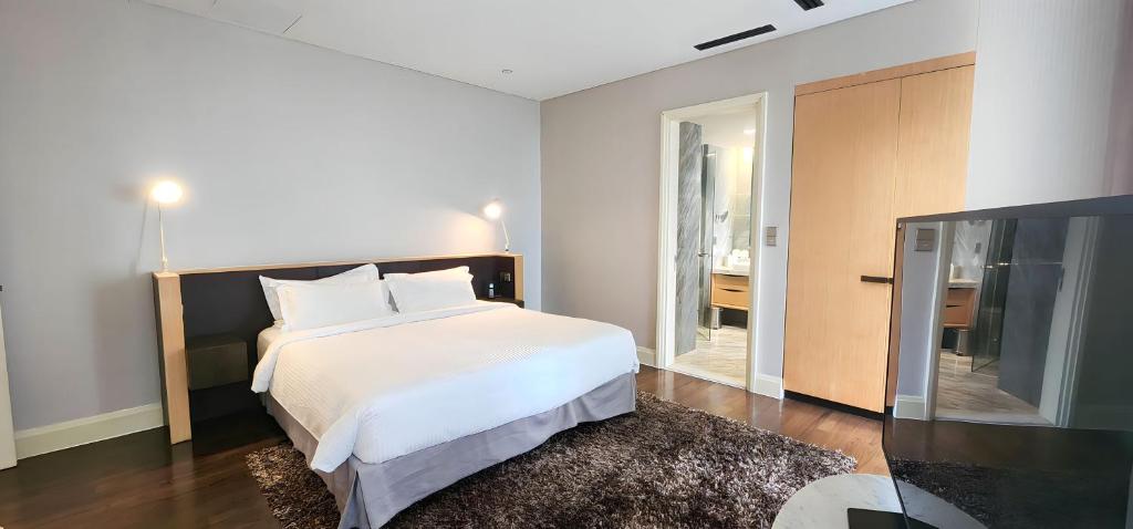 Giường trong phòng chung tại Ascott Raffles Place Singapore