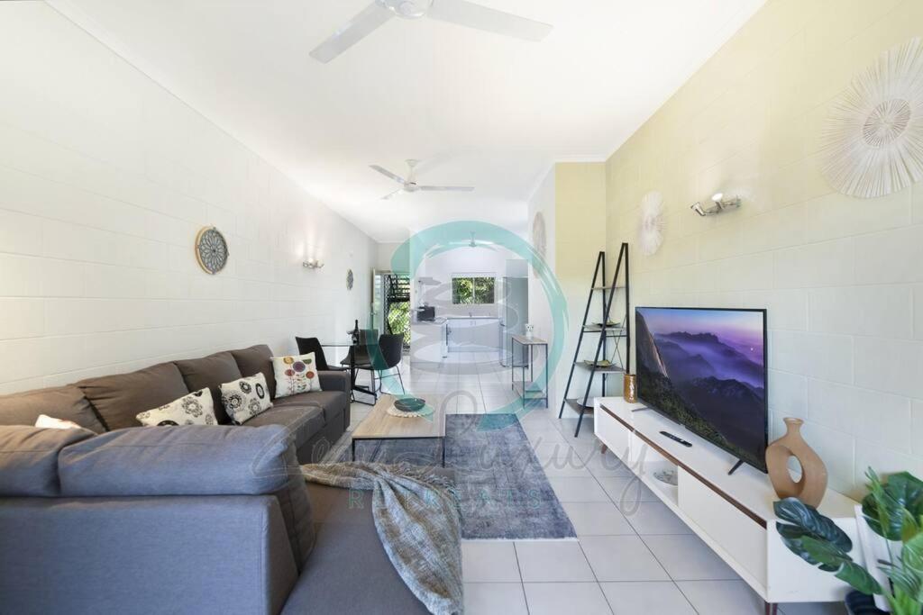 a living room with a couch and a tv at ZEN Westralia: 2-BR Cozy Inner-City Apt Near Shops in Stuart Park