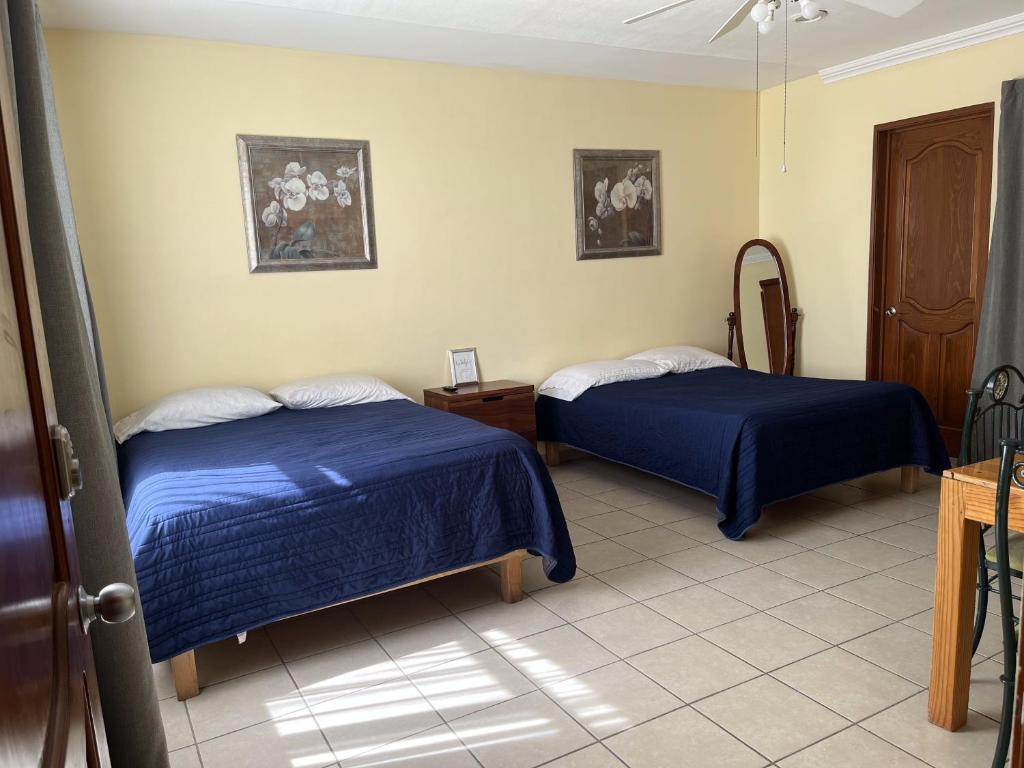 duas camas num quarto com lençóis azuis em La Casa Bonita de Pueblo Nuevo em El Pueblito