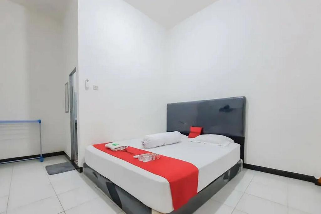 una camera bianca con un letto di RedDoorz at Permana Homestay near Supadio Airport Pontianak a Limbung