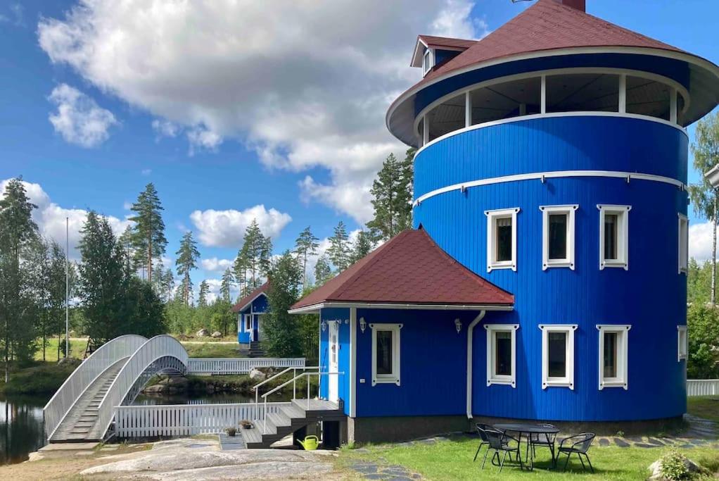 a blue tower with a slide next to a playground at Villa Muu, LaatuLomat in Juva