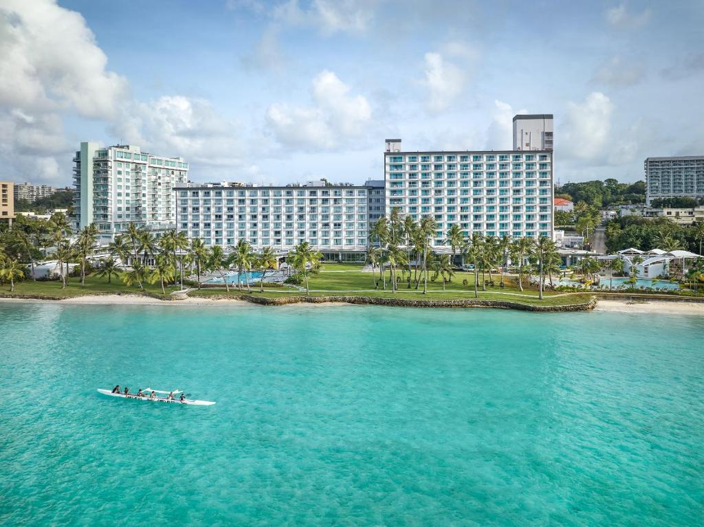 a group of people in a boat in the water with buildings at Crowne Plaza Resort Guam in Tumon