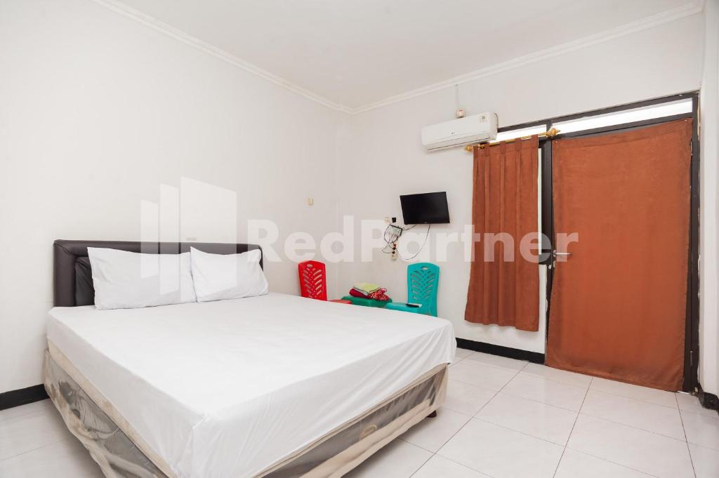 茂物的住宿－Wisma Juanda Bogor Mitra RedDoorz，卧室设有一张白色大床和一扇窗户。