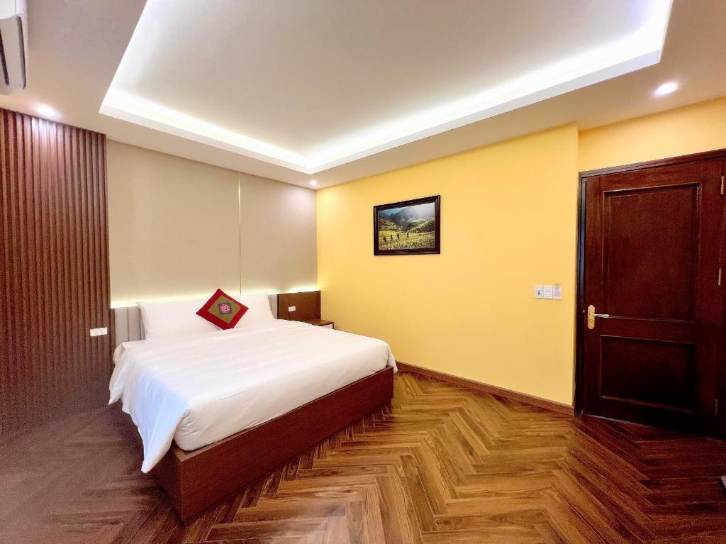 a bedroom with a large bed and yellow walls at An Khang Hotel Sapa in Sapa