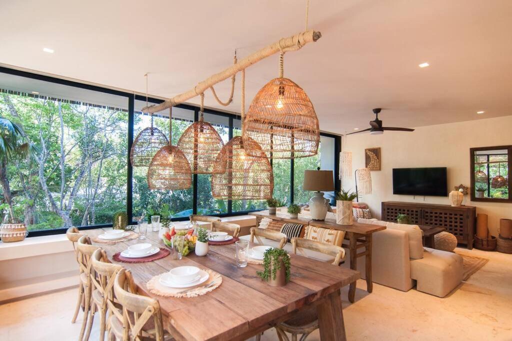 a dining room with a wooden table and chairs at Spectacular Villa Gaia/PH/private pool in Tulum