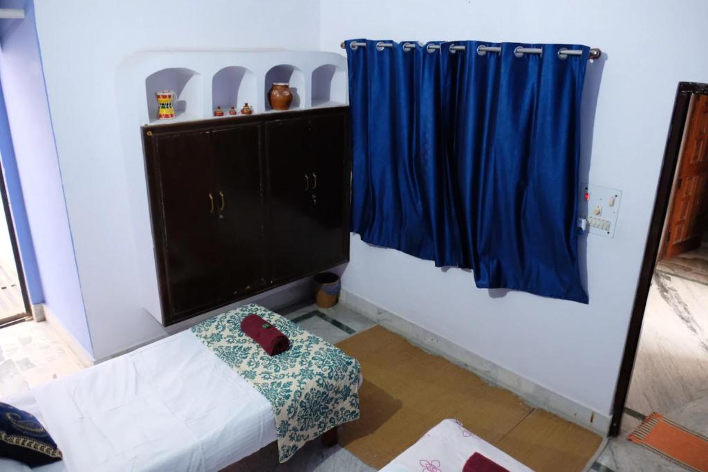 Habitación con sofá y cortina azul en Goroomgo Kashi Inn Varanasi Near Railway Station, en Varanasi