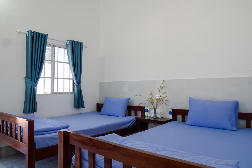 a room with two beds and a window at Nhà Nghỉ Vườn Oải Hương LAVENDER GARDEN GUEST HOUSE in Phu Quoc