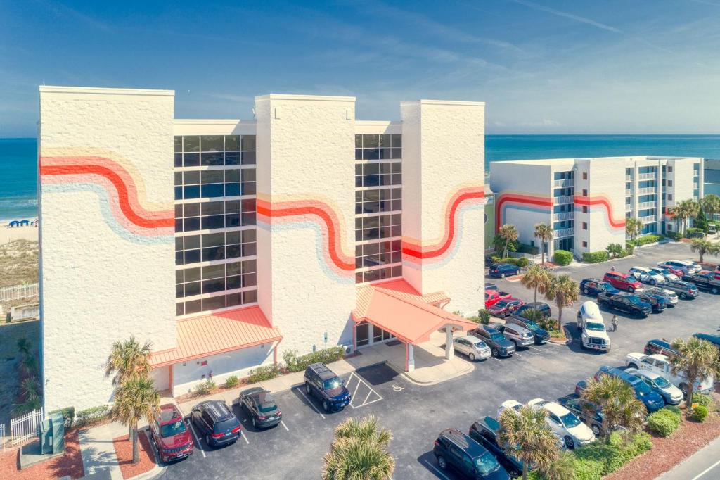 een luchtzicht op een hotel met auto's geparkeerd op een parkeerplaats bij Golden Sands Oceanfront Hotel in Carolina Beach