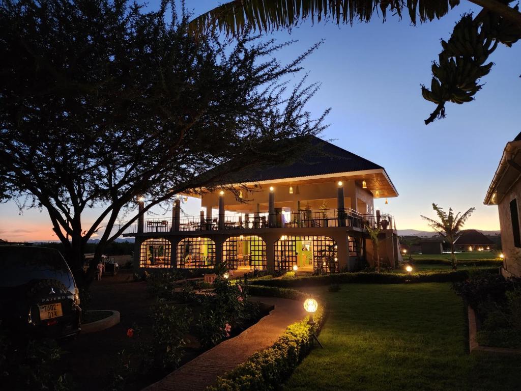 una casa con luces en el patio por la noche en Heart and Soul Lodge, en Karatu