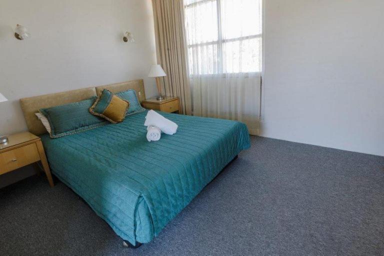 a bedroom with a bed with two towels on it at Lochinvar Hotel Motel in Lochinvar