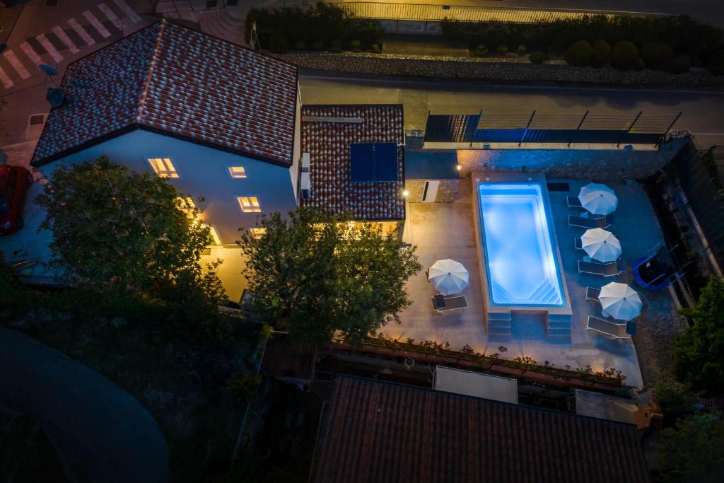 una vista aérea de una piscina por la noche con sombrillas en Casa Allegra, en Mali Lošinj