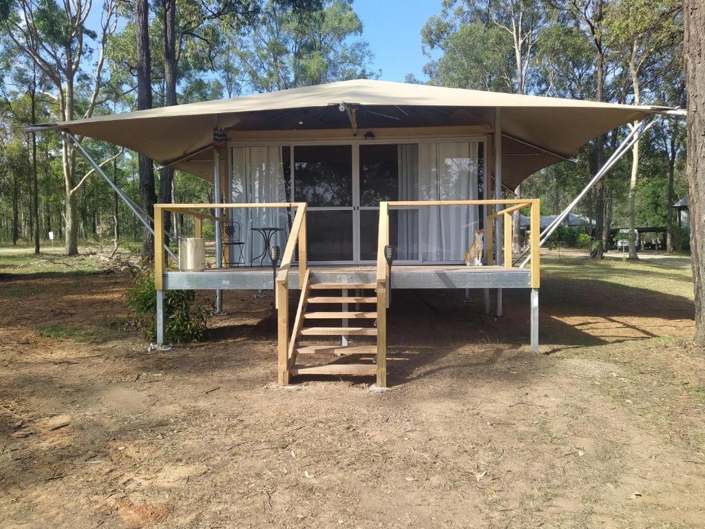 einen Pavillon mit einer Veranda und einer Treppe vor der Unterkunft in der Unterkunft Two Fat Blokes African Safari Glamping in Pokolbin