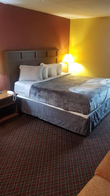 a hotel room with a large bed with two pillows at OSU 2 Queens Hotel Room 107 Hot Tub Booking in Stillwater