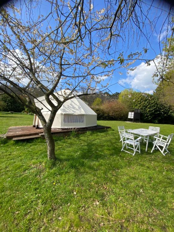 a table and chairs in a field with a building at Loire Valley Llama Farm Stay in Lavernat