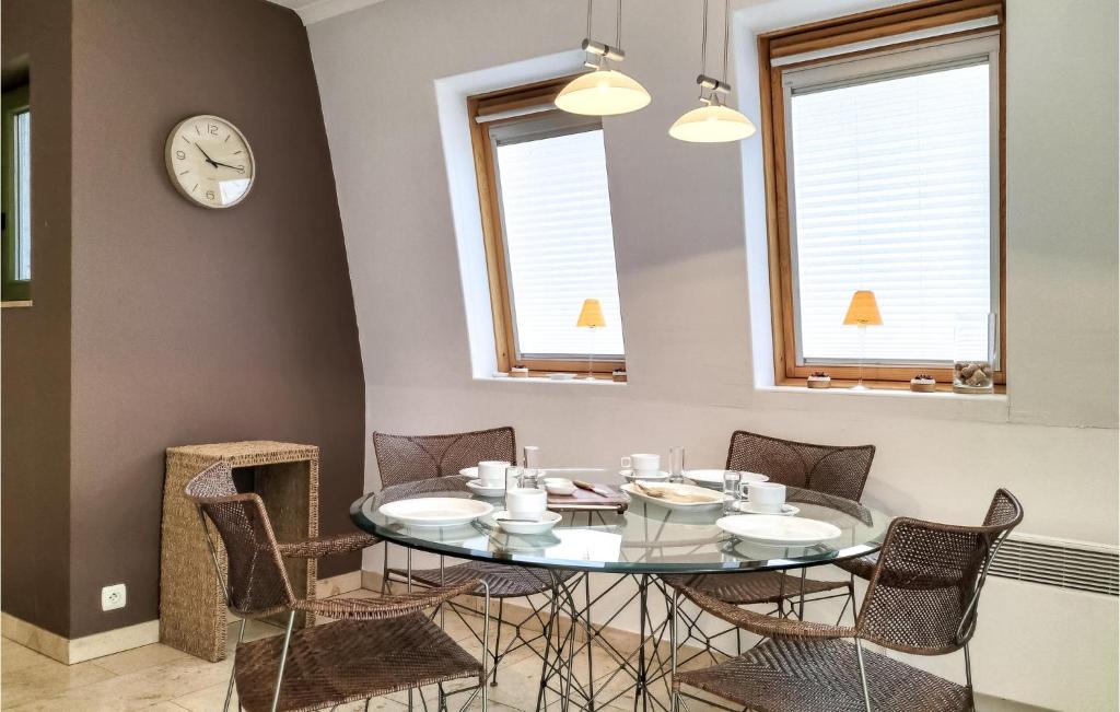 a dining room with a glass table and chairs at Nice Apartment In Bredene With Kitchen in Bredene