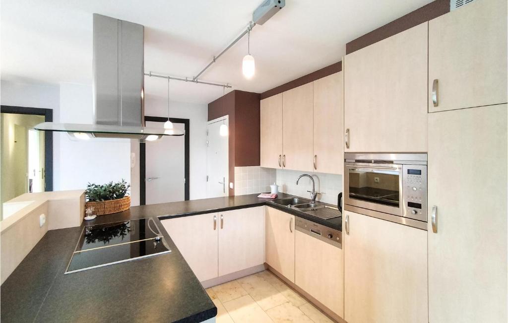 a kitchen with white cabinets and stainless steel appliances at Nice Apartment In Bredene With Kitchen in Bredene