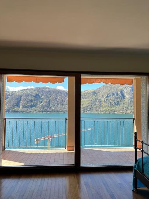 una camera con vista sull'acqua attraverso una finestra di Monolocale con vista lago a Campione dʼItalia