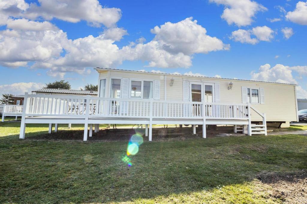 a house with a porch and a kite in the yard at 6 Berth Caravan For Hire With Sea Views At Haven Seashore Ref 22087a in Great Yarmouth