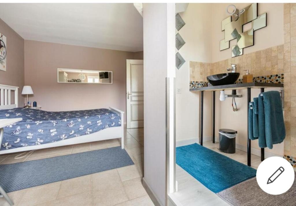 a bedroom with a bed and a bathroom with a sink at Chez Cathie à Muret in Muret