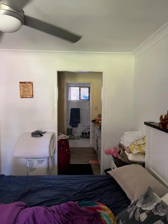 Schlafzimmer mit einem Bett, einem Schreibtisch und einem Fenster in der Unterkunft KnK Island Retreat in Russell Island