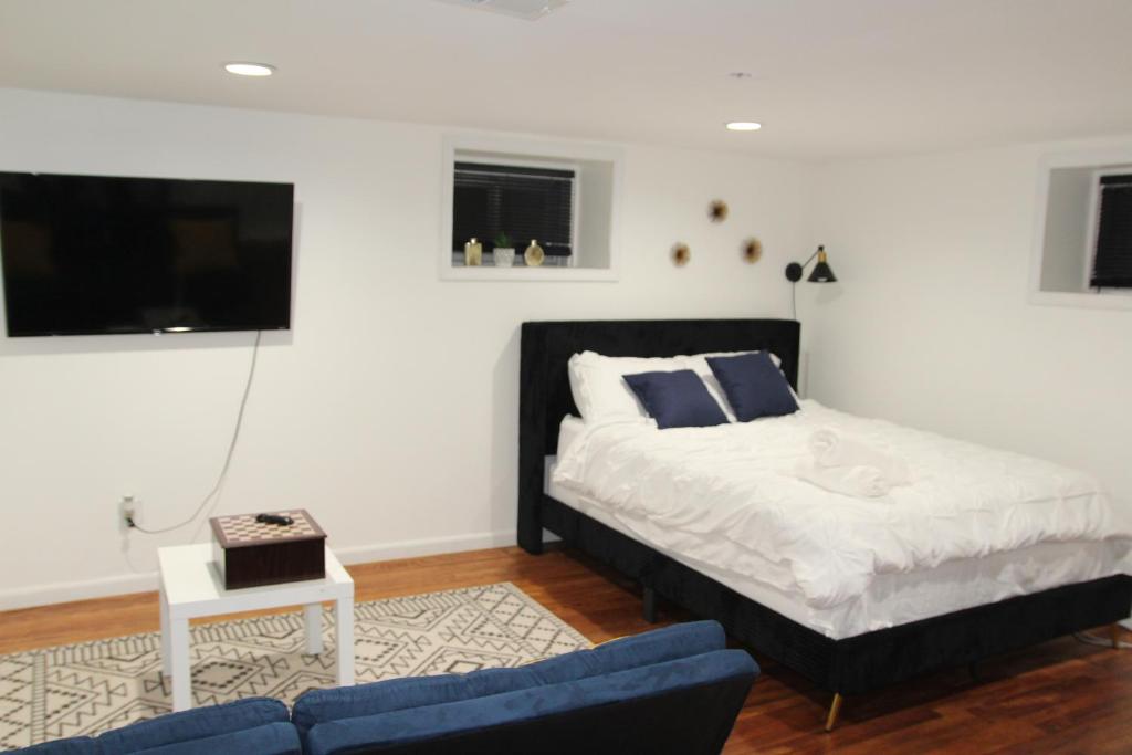 a bedroom with a bed and a couch and a tv at Lovely Private 2 Bedroom Suite near EWR/NYC in Newark